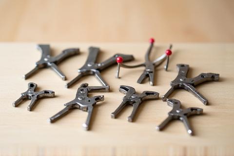 Assortment of miniature clamps and pliers for delicate model assembly.